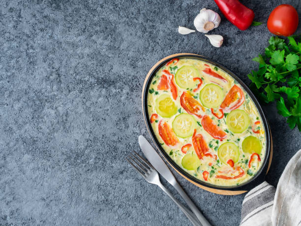 istock Scrambled eggs  with mix of colorful vegetables.  Beautiful appetizing dinner. Top view, copy space, dark gray stone table. 945052544