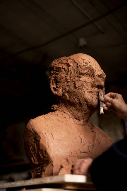 istock Sculptor's hand working on clay bust detail 945052630