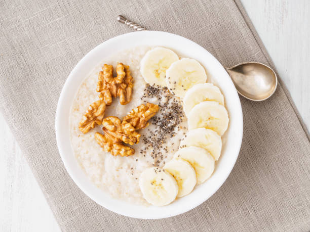 istock healthy breakfast - oatmeal with nuts, bananas, chia, top view, close up 945052730