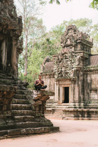 homem sentado no templo de angkor, no camboja - cambodia monk buddhism angkor wat - fotografias e filmes do acervo