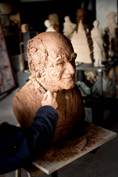 istock Sculptor's hand working on clay bust detail 945054048