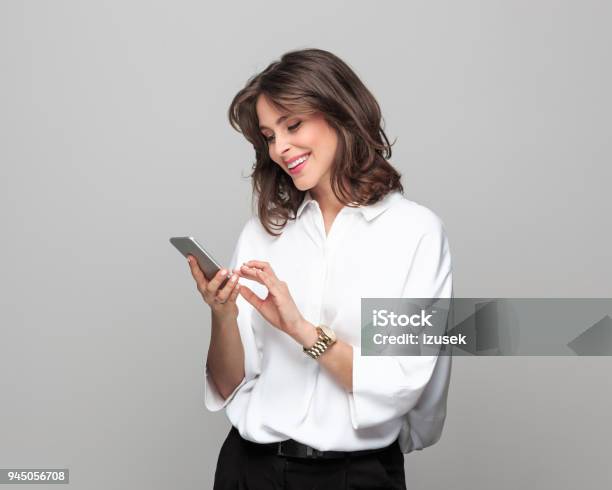 Beautiful Young Businesswoman Using Smart Phone Stock Photo - Download Image Now - Smart Phone, Women, Businesswoman
