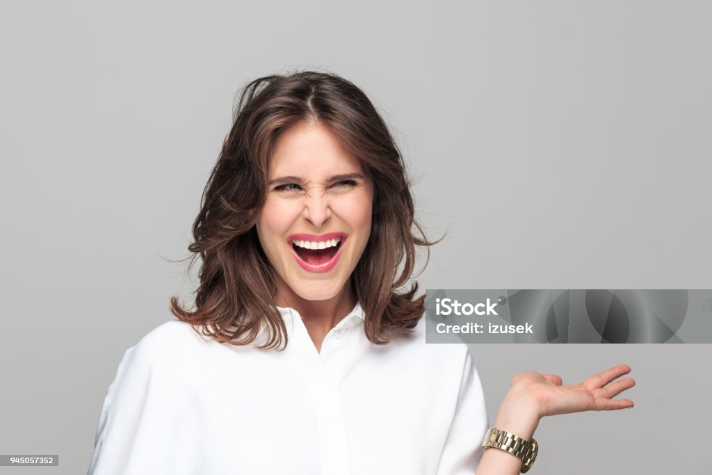 Portrait of angry young businesswoman Portrait of angry young businesswoman screaming at camera against grey background. 25-29 Years Stock Photo