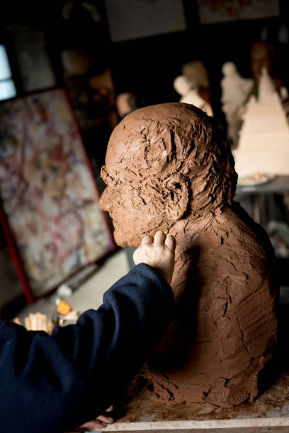 istock Sculptor's hand working on clay bust detail 945061714
