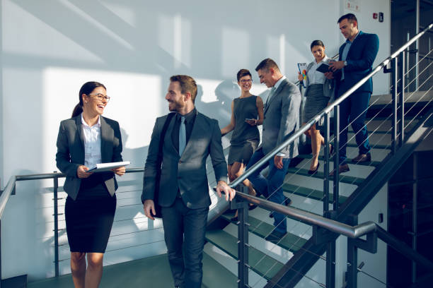 istock Group of business people walking down stairs and communicating 945062642