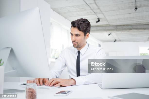 Young Businessman Working On Computer In Office Stock Photo - Download Image Now - Financial Advisor, 25-29 Years, Adult