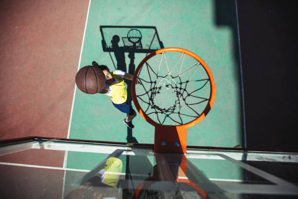 istock Woman basketball player doing a slam dunk 945069308