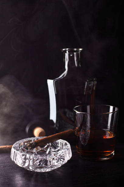istock Glass of whiskey with smoking cigar. 945070334