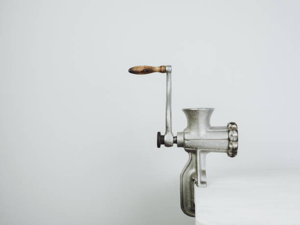Antique, vintage meat grinder on a white wooden table