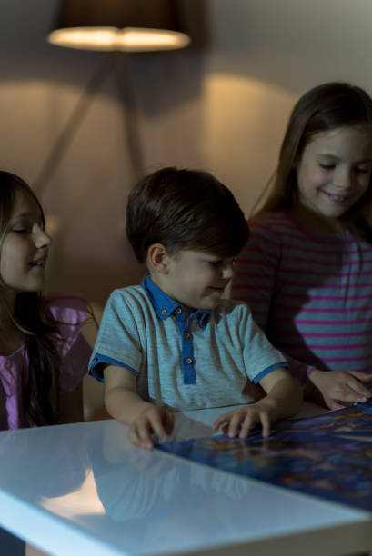 istock Little boy and two girls reading before sleep 945074594