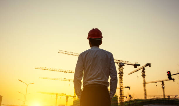 Engineer with crane background at sunset Engineer with crane background at sunset foreman stock pictures, royalty-free photos & images