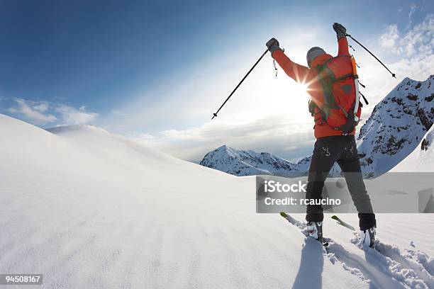 Skier Reaches His Arms Up Over A Snowy Mountain Landscape Stock Photo - Download Image Now