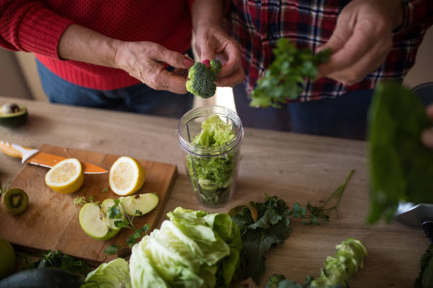 istock Senior couple preparing ingredients for green smoothie 945085678