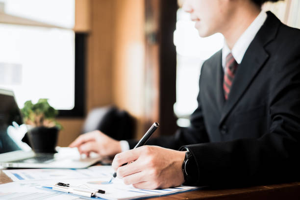 istock young businessman working with mobile laptop and documents in office, business concept 945085790