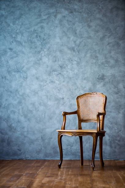 old chair on a gray wall background stock photo