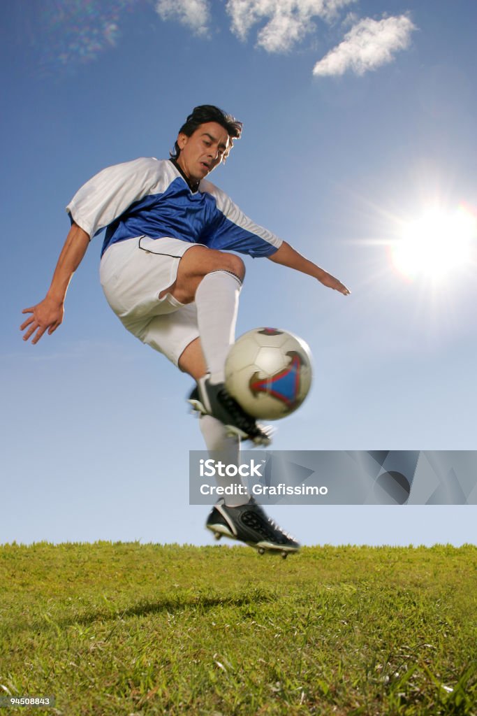 Jogador de futebol chutando a bola jumping - Foto de stock de Adulto royalty-free