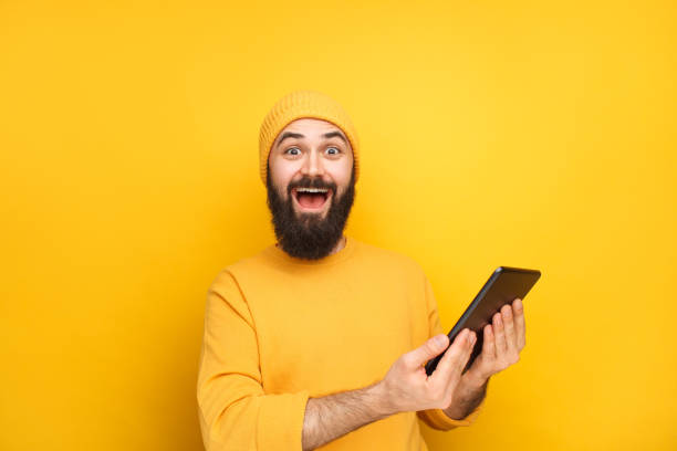 Excited guy in yellow with tablet