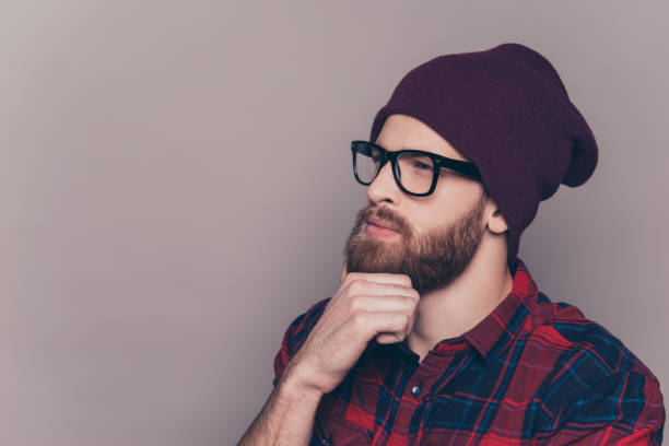 istock Young handsome thoughtful bearded man in hat and glasses 945088748