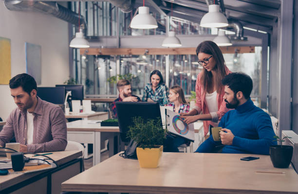 Young woman showing diagrama of growth to her colleague Young woman showing diagrama of growth to her colleague coworking stock pictures, royalty-free photos & images