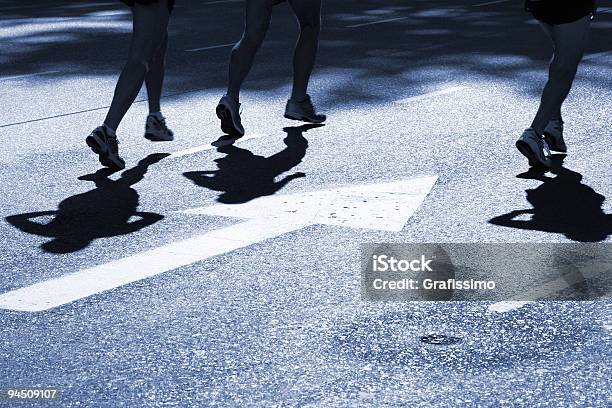 Pista Asfaltada Sombras De Três Corredores De Maratona - Fotografias de stock e mais imagens de Sinal de Seta