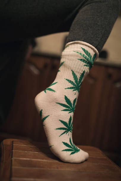 istock White socks with green herbal print on wooman leg on the kitchen 945097940