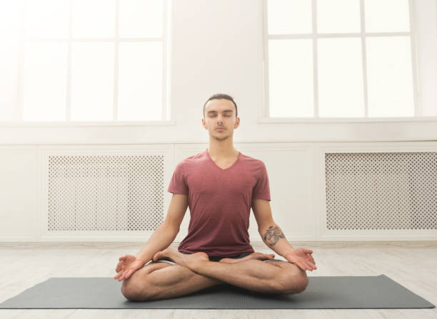 istock Young man practicing yoga, relax meditation pose 945098180