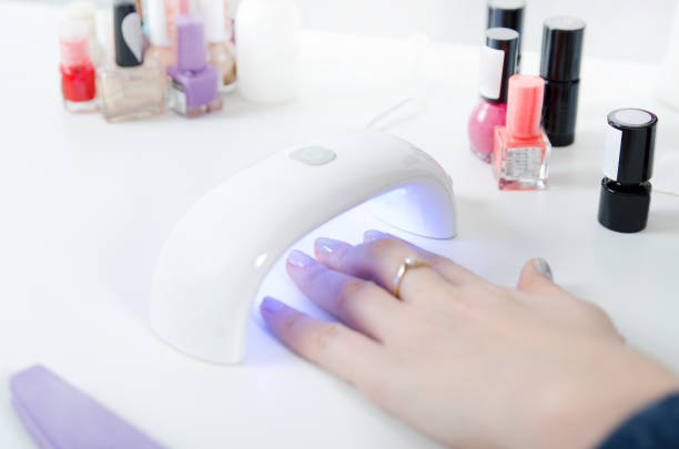 istock Woman using UV light dryer. Manicure, spa salon concept 945100530