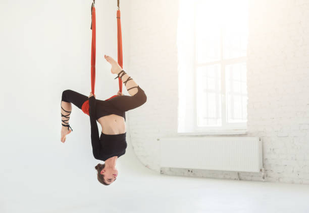 istock Woman practicing fly yoga over white background 945100994