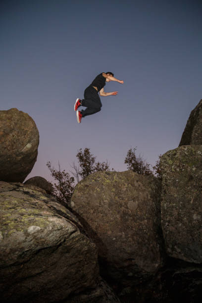 istock Man performing parkour trees in nighttime 945101442