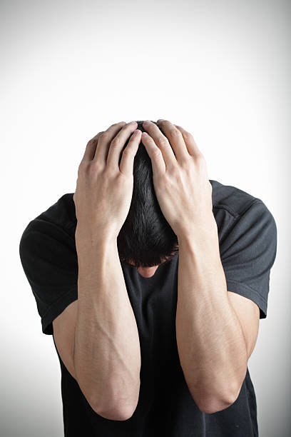 istock young man in despair covering head with hands 94510646