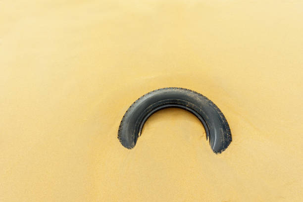 ecology wheel from the car lies in the sand stock photo