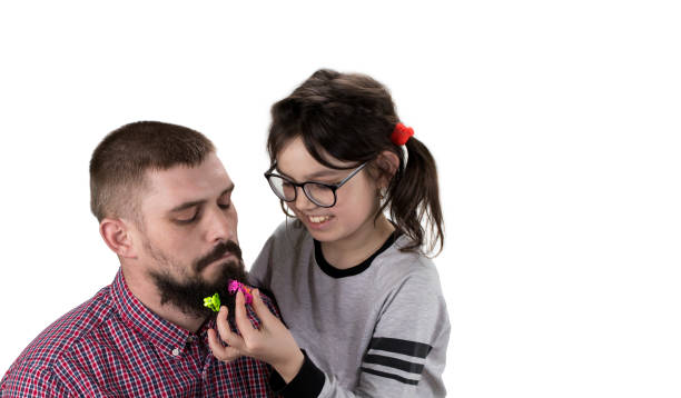 pai e filha jogando juntos. menina é brincar com o seu pai e fazer seu penteado. isolado no branco - oneparent - fotografias e filmes do acervo