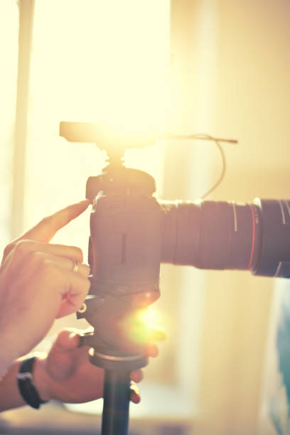 istock Camera in yellow sparkle sun highlights hand touch 945113470
