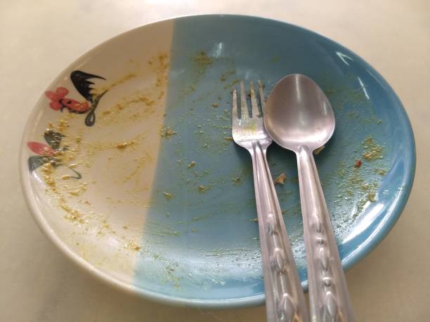istock Empty blue mixed white ceramic dish with traditional Thai style chicken tracery on the dish spoon and fork on top view. After meal let be full and sleepy. Thai culture must eat until last rice seed. 945114088