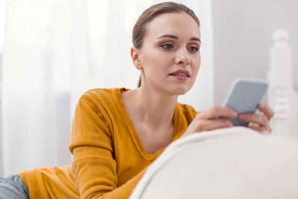 istock Pensive young woman typing response 945117438