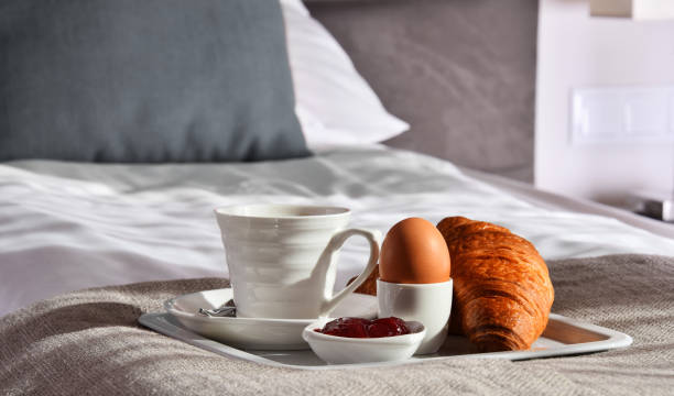 istock Breakfast on tray in bed in hotel room 945120036