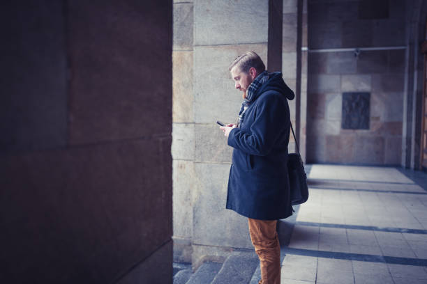 istock Ginger businessman using mobile phone outdoors 945120300