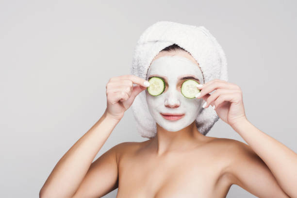 istock Beautiful girl with applied clay mask at white background 945120460