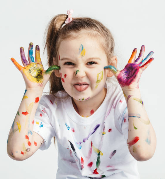 istock Little girl covered in paint making funny faces. 945121110