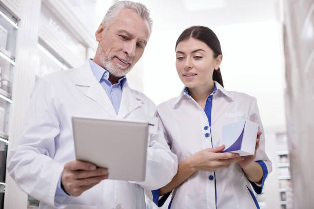 istock Attentive female pharmacist asking advice from colleague 945123878