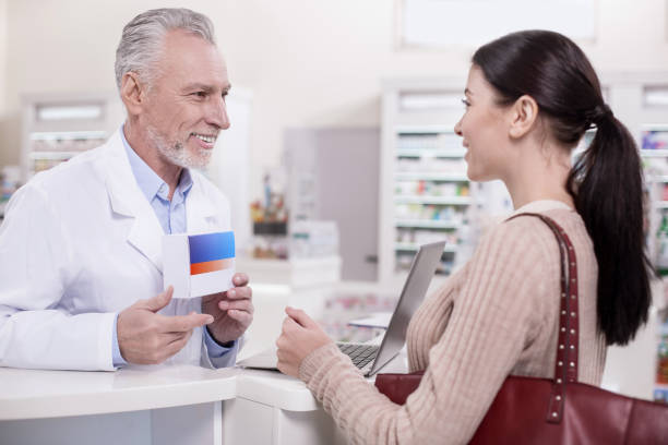 istock Cheerful male pharmacist advising client 945124738