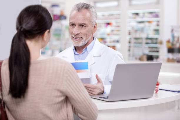 istock Positive male pharmacist giving advice client 945124764