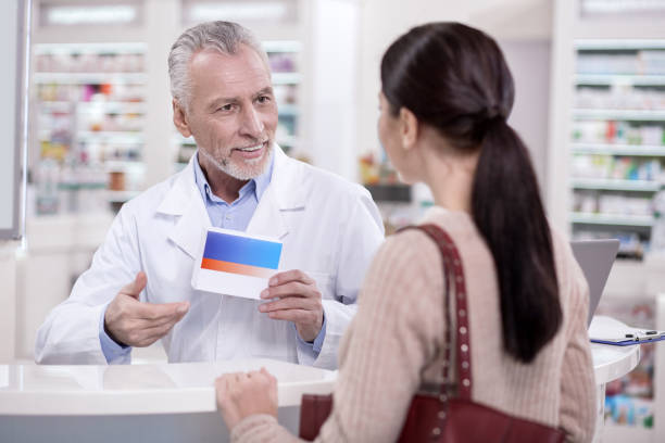 istock Happy male pharmacist offering medication 945124810