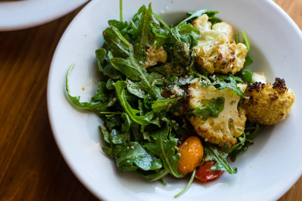 istock roasted cauliflower salad with mixed greens and cherry tomatoes 945125618