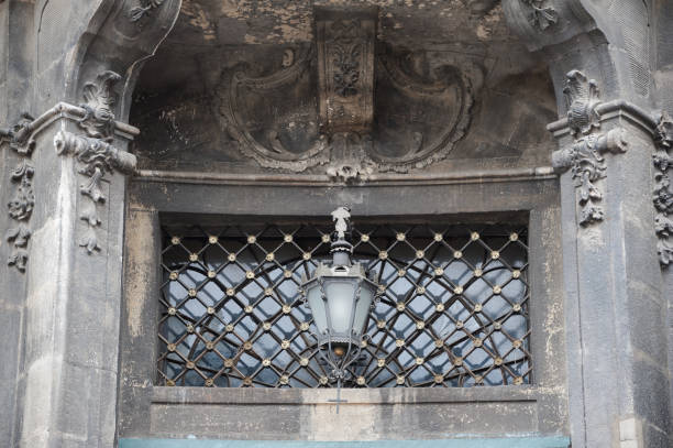 Vintage baroque window with metal grill and lamp. Fragment of the Dominican Cathedral facade, situated in the centre of Lviv, Ukraine.