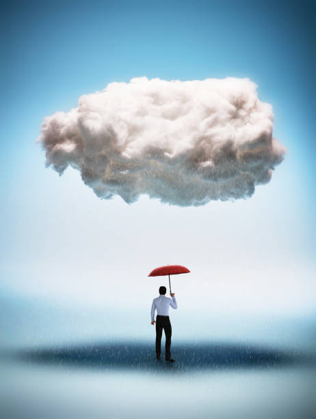 uomo d'affari con un ombrello rosso in piedi sotto una grande nuvola - financial burden foto e immagini stock