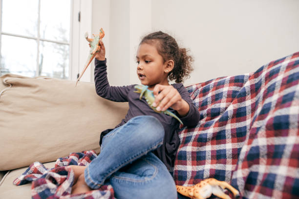 istock A Girl Playing with Dinosaurs 945132942