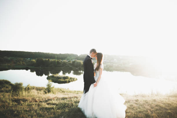 istock Newly married couple running and jumping in park while holding hands 945145118