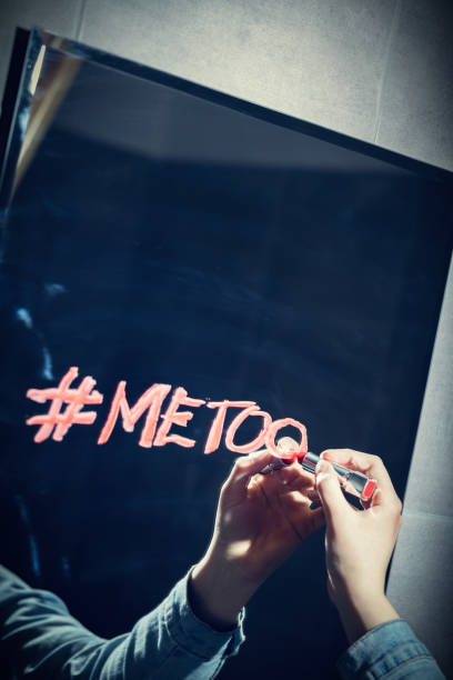Girl writing "#metoo" on a mirror with a red lipstick. Girl writing "#metoo" on a mirror with a red lipstick. Sexual harassment. mirror writing stock pictures, royalty-free photos & images