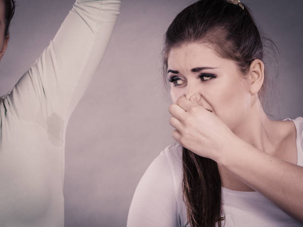 istock Woman having wet armpit her friend smelling stink 945145800
